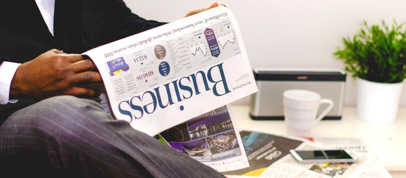 A businessman is reading the Business newspaper