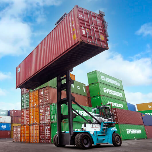 Container stacker crane lifting up a stacking container box in yard