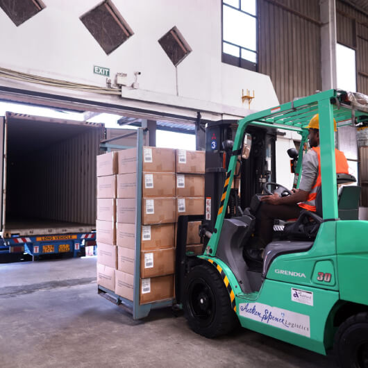 A forklift lifting cargo crates in the warehouse