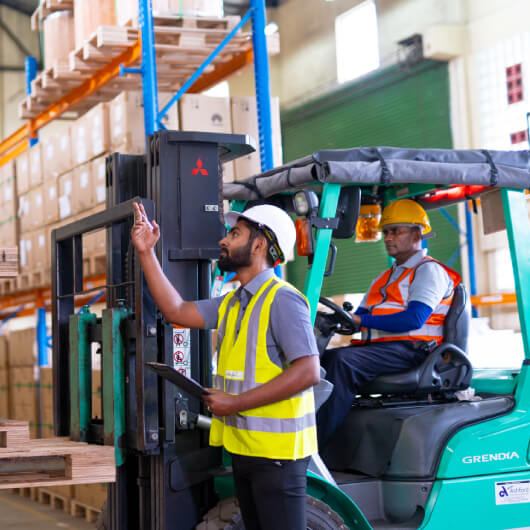 Workers in the warehouse with various goods stored in racks and shelves